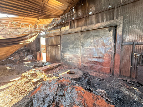 Interior de galpón siniestrado con sector afectado por incendio